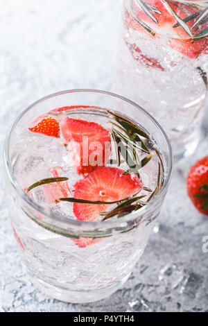 Boissons ou cocktails sans alcool avec des fraises et du romarin et de la glace dans des verres en verre Banque D'Images