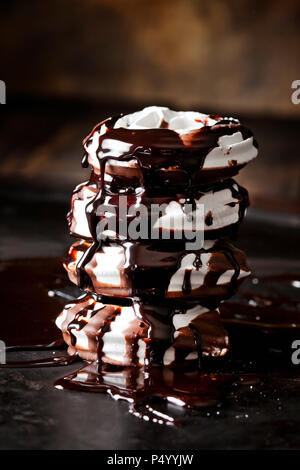 Pile de quatre pâtisseries de meringue avec une sauce au chocolat Banque D'Images