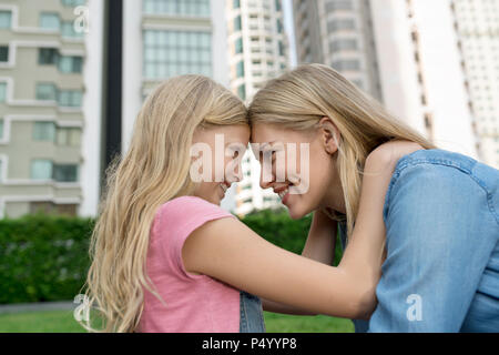 Happy mother and daughter in urban city garden Banque D'Images