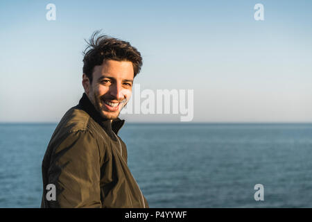 Portrait of smiling young man at the beach Banque D'Images