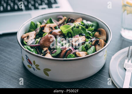 Boîte à lunch avec salade, oignons, champignons grillés, oignons et balsamico Banque D'Images