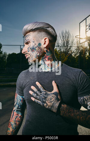 Portrait de jeune homme tatoué sur le terrain de basket-ball Banque D'Images