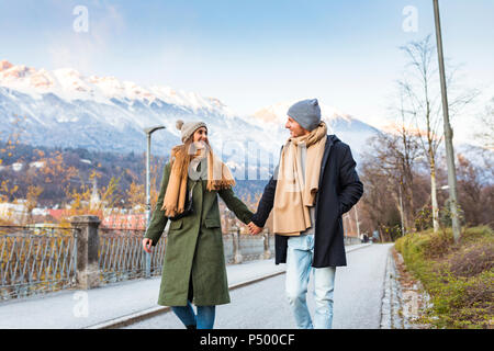 L'Autriche, Innsbruck, happy young couple strolling ensemble main dans la main à l'heure d'hiver Banque D'Images