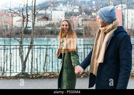 L'Autriche, Innsbruck, happy young couple strolling ensemble main dans la main à l'heure d'hiver Banque D'Images