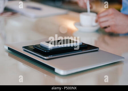 Pile d'appareils mobiles et de l'homme avec du café Banque D'Images