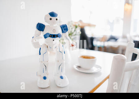 Robot miniature, figurine holding strawberries Banque D'Images