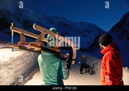 Couple avec Sled in snow-covered landscape at night Banque D'Images