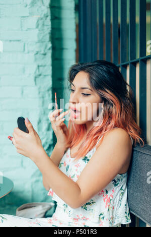 Portrait of young woman applying Lip Gloss Banque D'Images