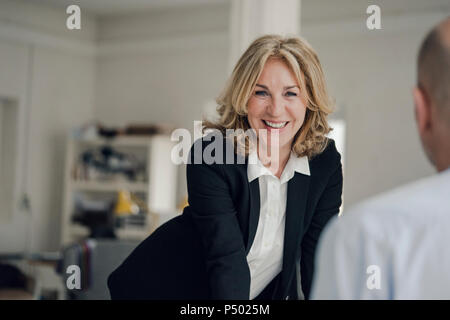 Smiling senior businesswoman looking at collègue Banque D'Images