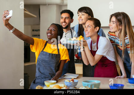 Les amis et l'instructeur dans un atelier de cuisine en tenant un selfies Banque D'Images