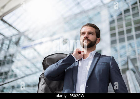 Portrait of young businessman on escalator Banque D'Images