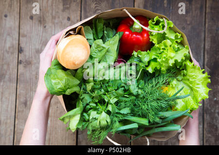 Femme Sac en papier plein de provisions sur fond de bois. À partir de ci-dessus. Vue d'en haut. Banque D'Images