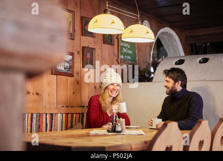 Happy couple drinking boisson chaude au refuge de montagne rustique Banque D'Images