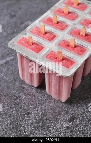 Sucettes glacées aux fraises faites maison dans le bac Banque D'Images