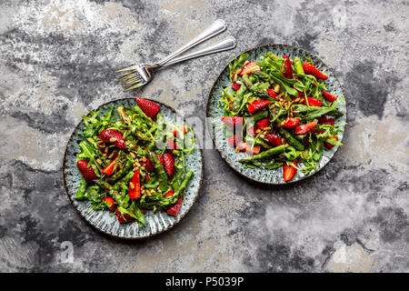 Salade d'asperges vertes, roquette, les fraises et les noix de pin Banque D'Images