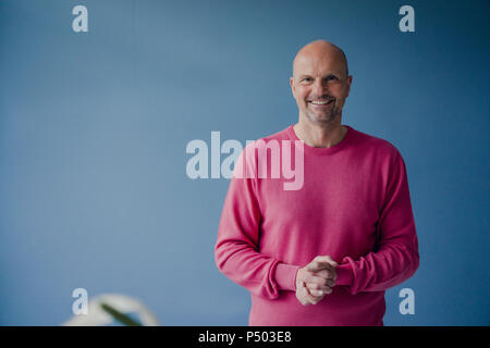 Portrait of smiling man wearing pull rose Banque D'Images