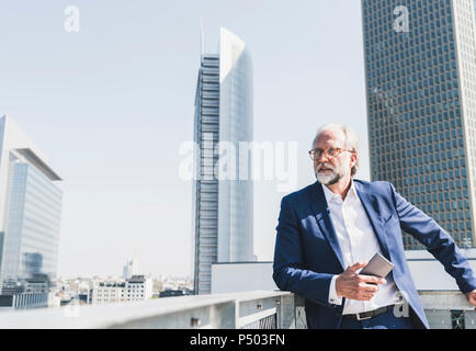 Mature businessman with cell phone dans la ville à travers Banque D'Images