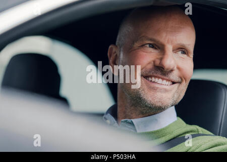 Portrait of smiling young man in car Banque D'Images