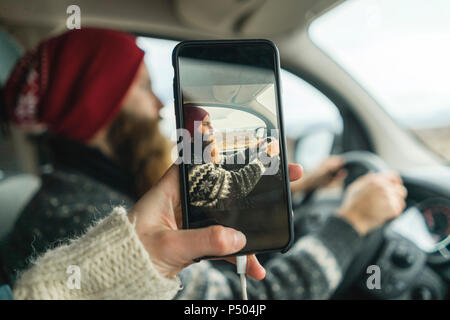 L'Islande, woman taking photo de son petit ami van de conduite Banque D'Images