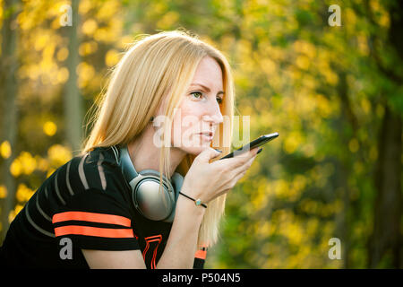 Portrait de femme blonde avec un casque using smartphone Banque D'Images