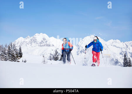 Autriche, Tyrol, randonneurs en raquettes dans la neige en cours d'exécution Banque D'Images