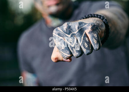 Close-up du poing serré du jeune homme tatoué à l'extérieur Banque D'Images