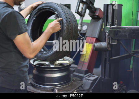 Mécanicien professionnel en utilisant la machine pour changement de pneus. Banque D'Images