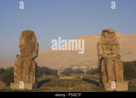 Colosses de Memnon. Statues en pierre représentant le pharaon Amenhotep III (14ème siècle avant J.-C.) en position assise. Vue panoramique. Dix-huitième dynastie. Nouveau Royaume. Luxor. L'Égypte. Banque D'Images