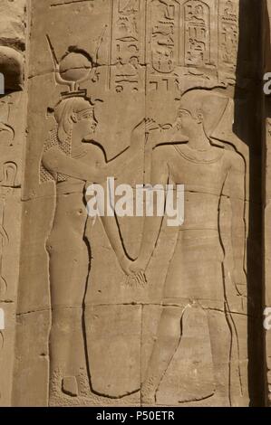 L'Égypte. Edfou. Temple d'Horus. Relief représentant une divinité égyptienne de donner la clé de la vie, l'ankh, le Pharaon. Banque D'Images