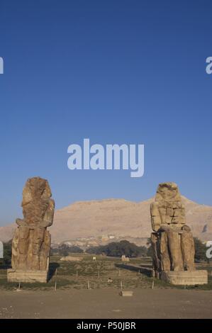 Colosses de Memnon. Statues en pierre représentant le pharaon Amenhotep III (14ème siècle avant J.-C.) en position assise. Vue panoramique. Dix-huitième dynastie. Nouveau Royaume. Luxor. L'Égypte. Banque D'Images