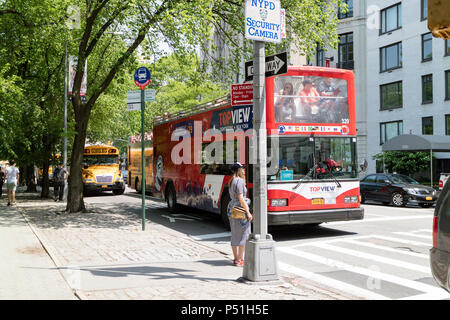 5e Avenue, New York, USA. Tour bus et un autobus scolaire sur cette route très fréquentée. Banque D'Images