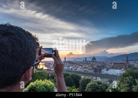 Florence, Toscane, Italie : Touristique prend une photo avec le smartphone de l'épatante Florence cityscape de Piazzale Michelangelo au coucher du soleil Banque D'Images