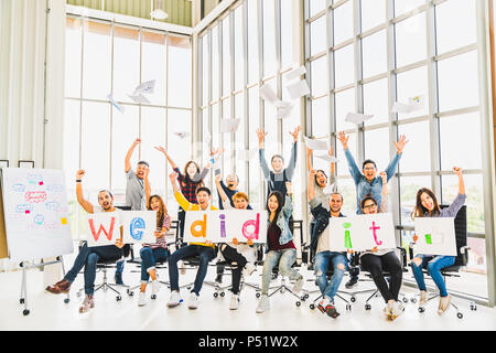 Groupe diversifié de multiethnique happy business people cheering ensemble, célébrer le succès du projet avec des papiers a écrit les paroles, il l'a fait. Concept d'équipe Banque D'Images