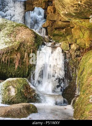 Les glaçons en cascade de glace. Pierres de neige et de glace et de rochers avec des gouttes d'eau froide tombés entre les rochers de grès. Banque D'Images