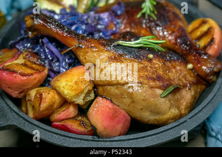 Morceaux de canard marinée grillée avec du chou rouge, les oignons et les pommes et grillés servis dans un style rustique. La structure horizontale. Banque D'Images