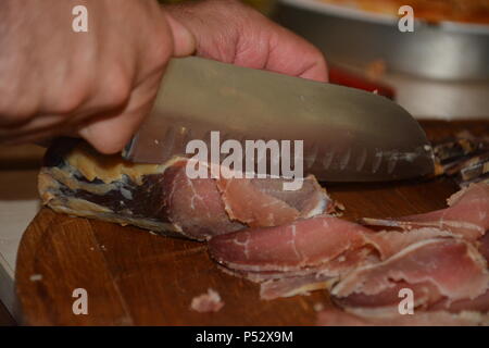 Couper la viande de porc de boucherie sur cuisine. Couper la viande de boeuf Chef de cuisine.Chef des matières premières fraîches (fumé) viande sur planche de bois. Couper les tranches de viande crue. Banque D'Images