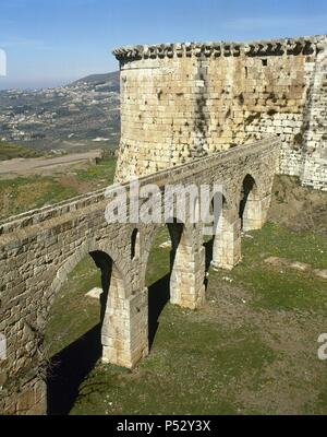 SIRIA. KRAK DE LOS CABALLEROS. Castillo levantado en el siglo XII por los Caballeros Hospitalarios, durante las cruzadas un Tierra Santa. Es la mejor muestra que se conserva en el Oriente Medio de arquitectura militar de l'époque médiévale. En el S. XIII, la fortaleza cristiana cayó en manos arabes. ACUEDUCTO en forma de puente que suministraba agua al aljibe. Banque D'Images