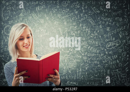 Teacher holding un livre rouge en face d'un immense tableau noir essayer de résoudre les mathématiques Calcul, équations et formules. Une pensée d'idées de projet Banque D'Images