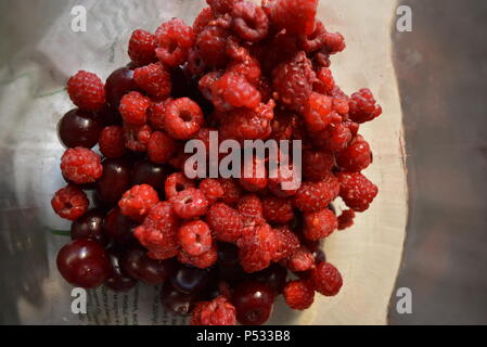 Produits, fruits frais, framboises rouges maison, cerises disposées dans un bocal en verre. Banque D'Images