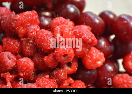 Produits, fruits frais, framboises rouges maison, cerises disposées dans un bocal en verre. Banque D'Images