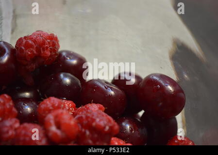 Produits, fruits frais, framboises rouges maison, cerises disposées dans un bocal en verre. Banque D'Images