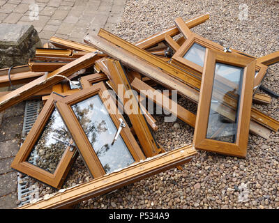 Une pile de bois en plastique mis au rebut des cadres de fenêtre ex effet étant remplacé par un parquet en chêne. Plus plastique et déchets de verre destinés à l'élimination en décharge Banque D'Images