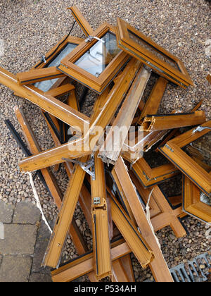 Une pile de bois en plastique mis au rebut des cadres de fenêtre ex effet étant remplacé par un parquet en chêne. Plus plastique et déchets de verre destinés à l'élimination en décharge Banque D'Images