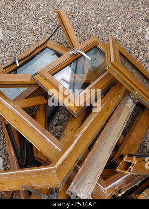 Une pile de bois en plastique mis au rebut des cadres de fenêtre ex effet étant remplacé par un parquet en chêne. Plus plastique et déchets de verre destinés à l'élimination en décharge Banque D'Images