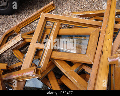 Une pile de bois en plastique mis au rebut des cadres de fenêtre ex effet étant remplacé par un parquet en chêne. Plus plastique et déchets de verre destinés à l'élimination en décharge Banque D'Images