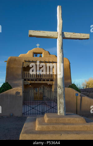 Une grande croix de bois ornent l'entrée de l'église Saint Thomas d'adobe dans Abiquiú, Nouveau Mexique. Banque D'Images