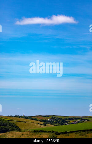 Un nuage blanc dans un ciel bleu sur le paysage ondulé Cornish sur la rame péninsule dans la hauteur de l'été, Cornwall, Angleterre Banque D'Images