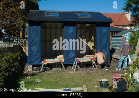 Ceux qui construisent un grand abri dans un jardin Banque D'Images