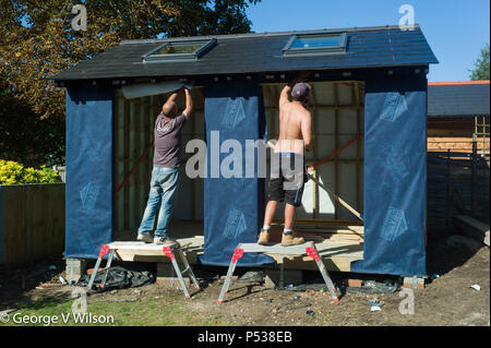 Ceux qui construisent un grand abri dans un jardin Banque D'Images