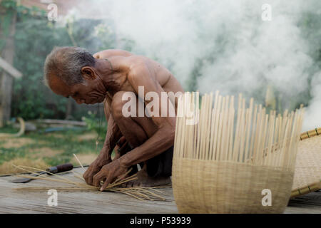 Vieil homme tisse des paniers de la Thaïlande. Banque D'Images